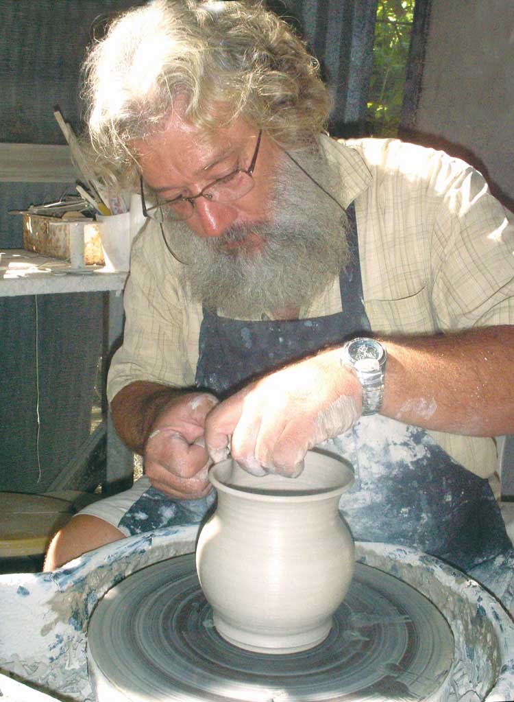 Chuck Koucky throwing at his potter's wheel.